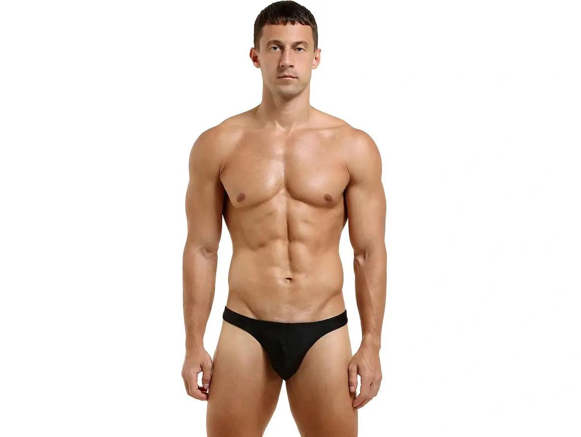 Black seamless low-rise thong for men featuring wide waistband and modest pouch design
