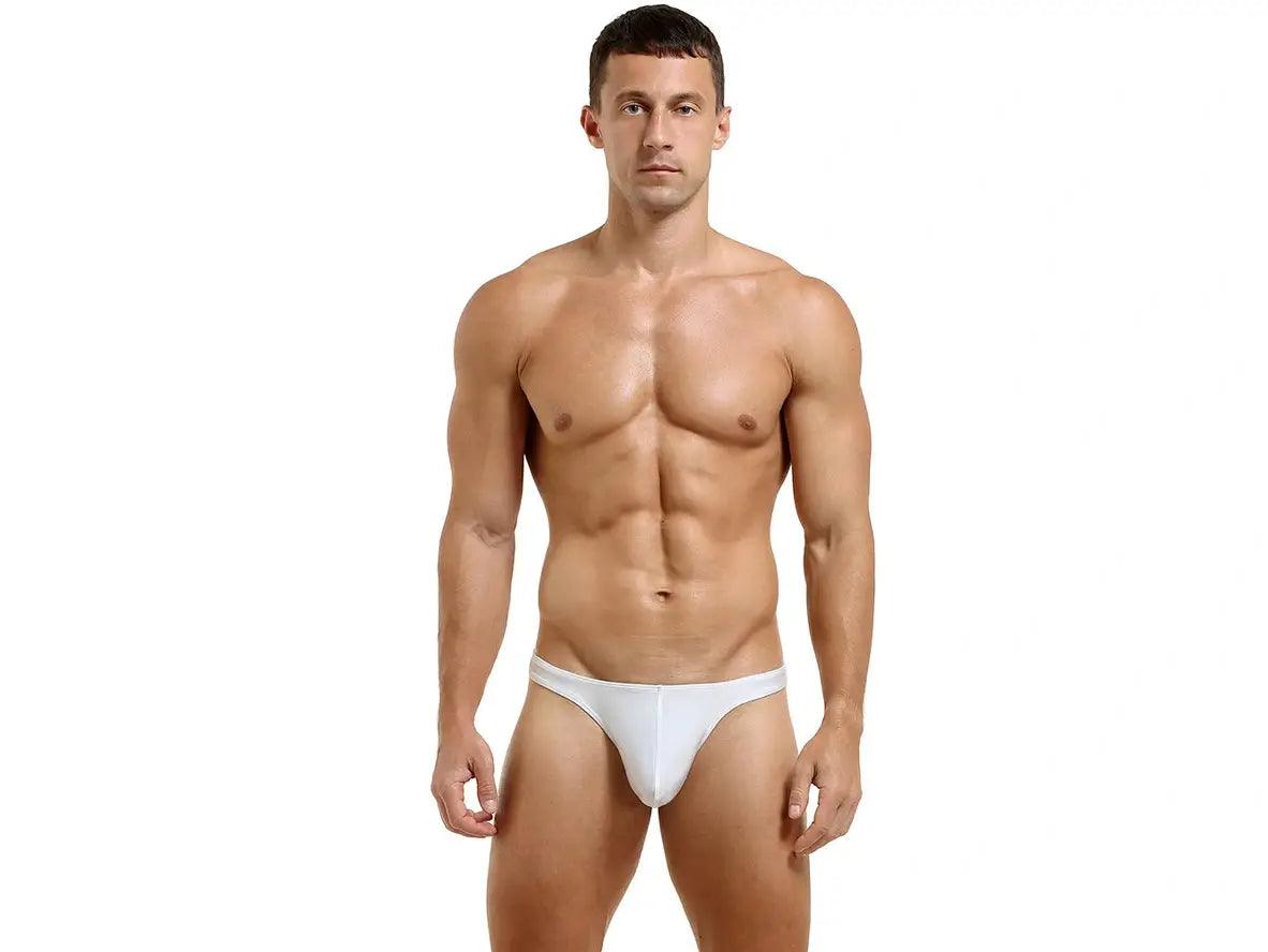 White low-rise thong full-frontal view with center seam and narrow waistband on muscular model