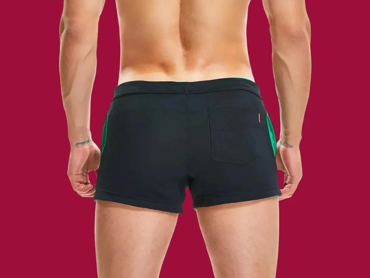 Black activewear shorts with green side accents and rear pocket back view