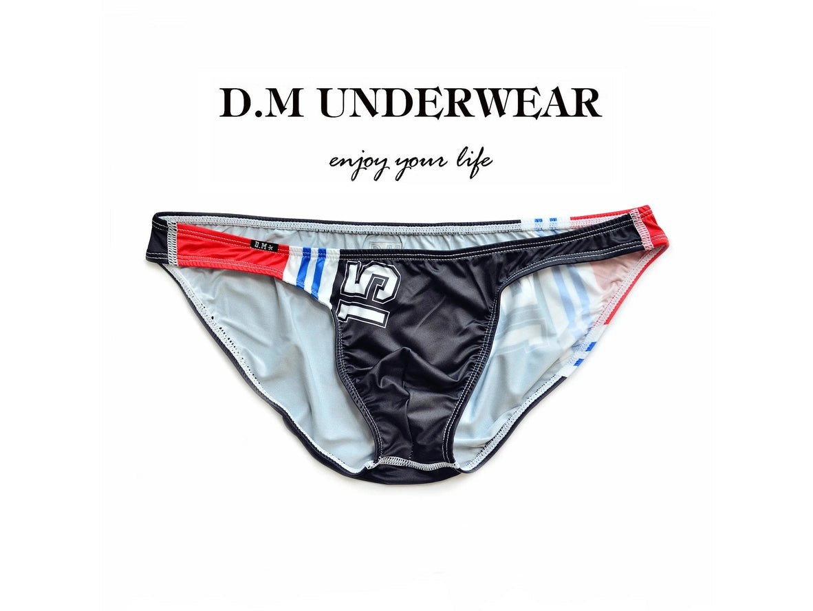 Black D.M ultra low-rise men's swimwear flat lay with red white blue accents