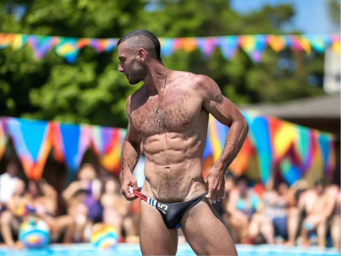 Black D.M ultra low-rise swim bikini worn poolside with rainbow flags in background