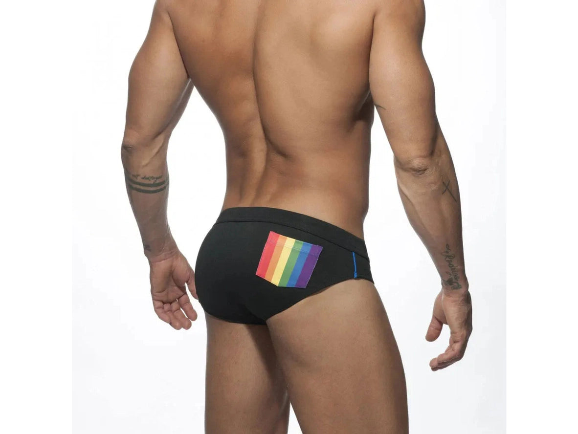 Black men's swim briefs with rainbow pocket patch on lower back