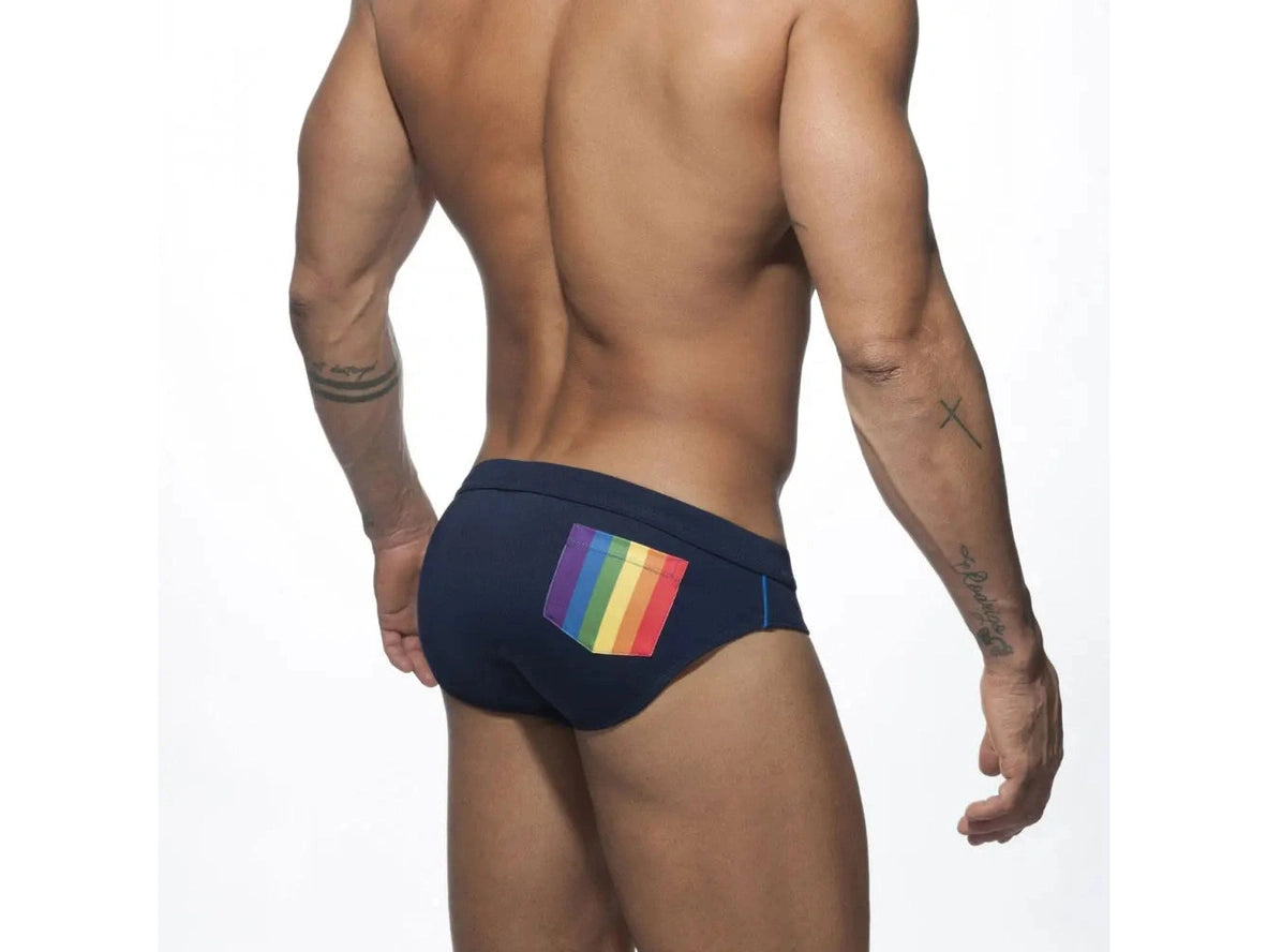 Navy blue men's swim briefs with rainbow striped back pocket