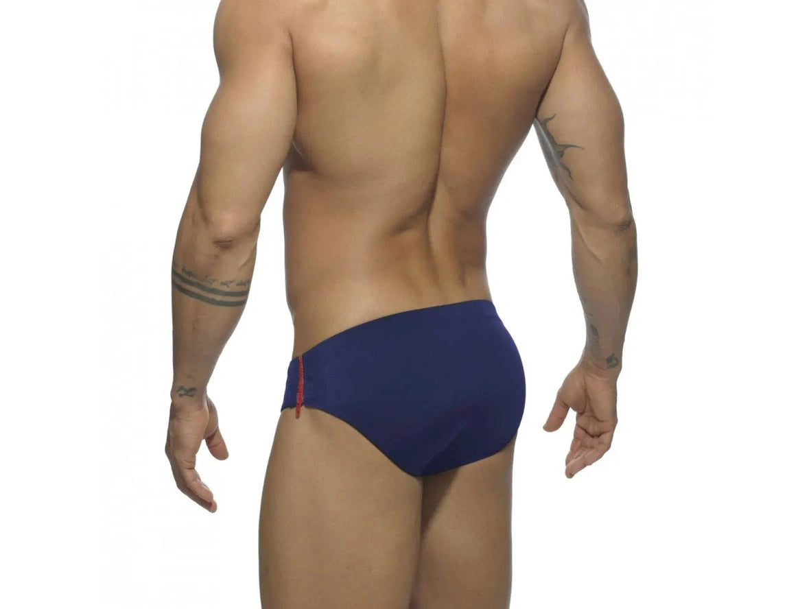 Back view of navy blue swim briefs with red side zipper accent