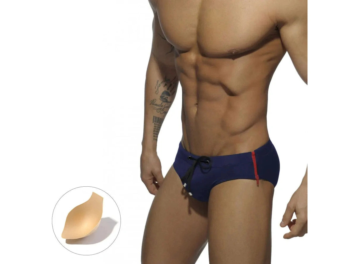 Navy blue swim briefs with red zipper and beige pushup pad inset