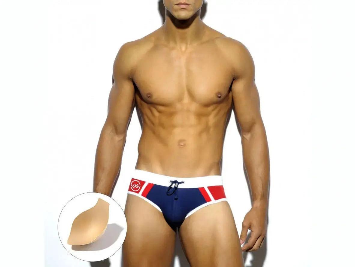 Navy blue low-rise swim briefs with red diagonal panels and adhesive chest pad
