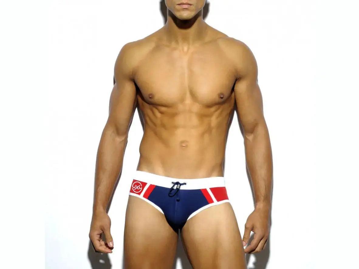 Navy blue men's swim briefs with white waistband, red panels, and black drawstring
