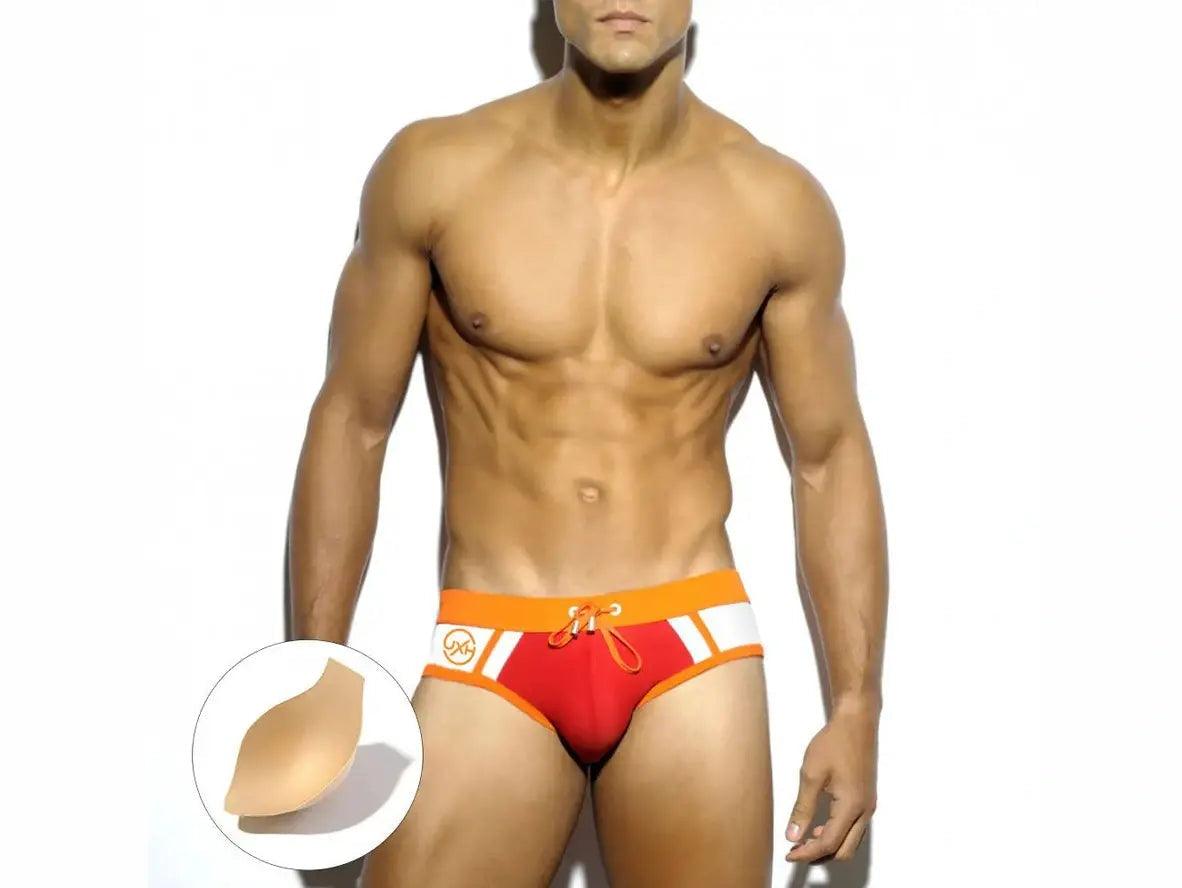 Red low-rise swim briefs for men with orange waistband and included chest pad