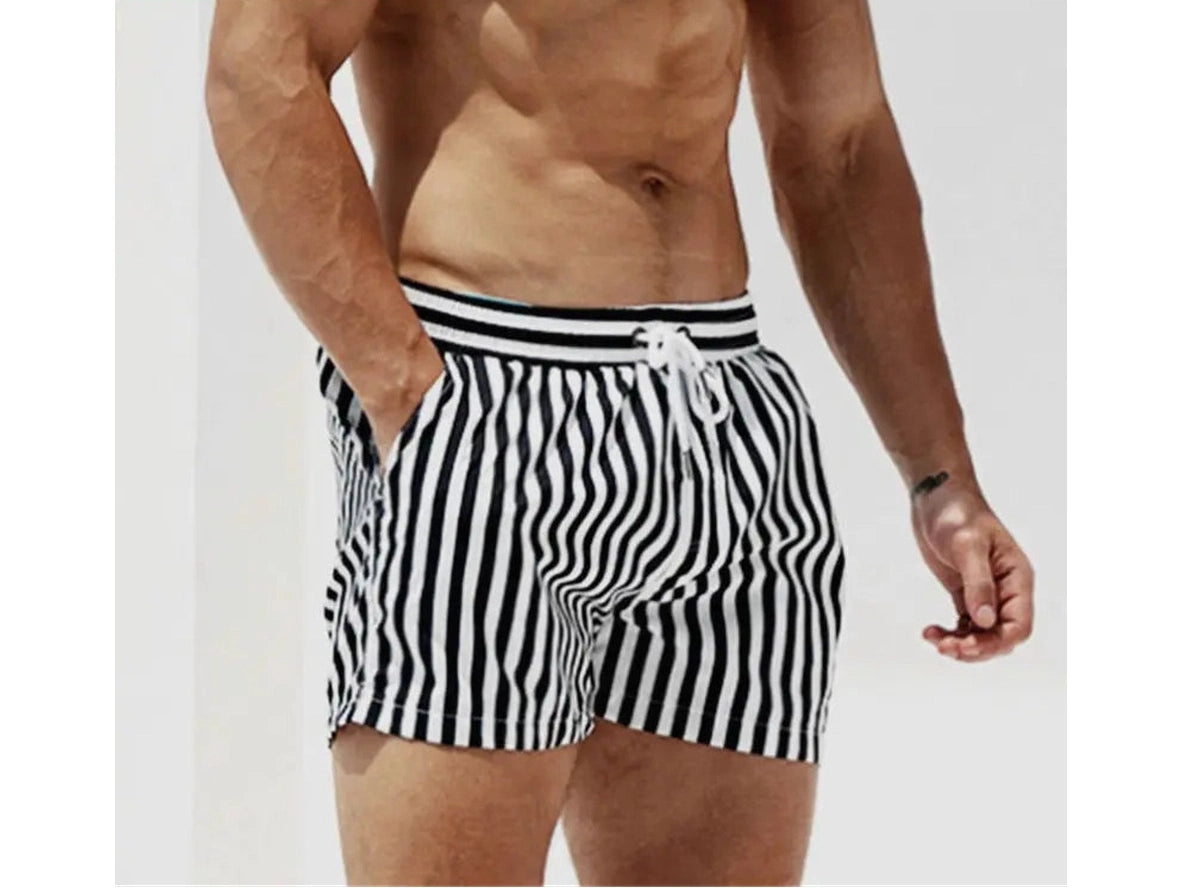 Model wearing black and white striped DESMIIT swim shorts front view