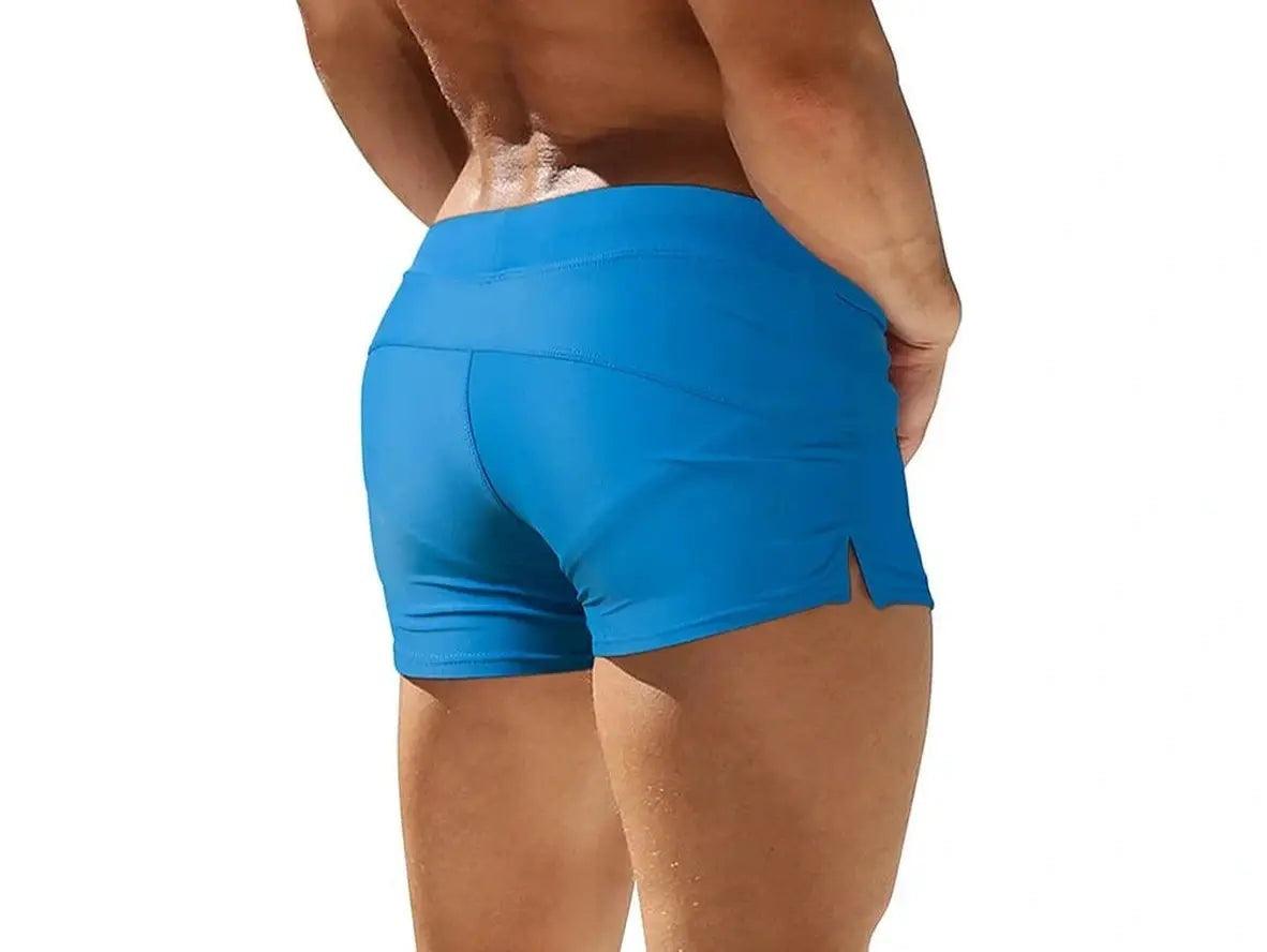 Blue men's swim trunks displaying high-waisted back seam detail and side slit