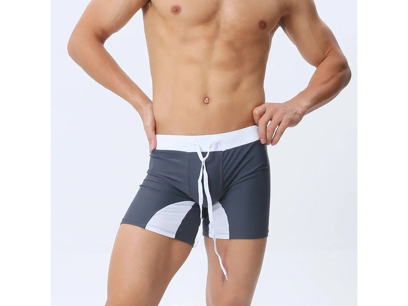 Navy blue low-rise swim trunks with yellow waistband and gray stripe detail