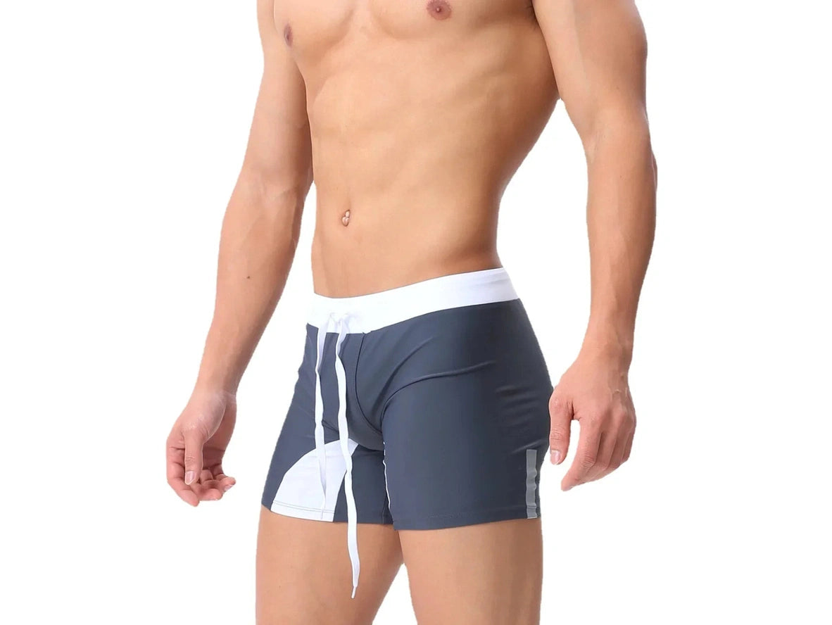 Dark gray contrast swim trunks featuring white curved panels and waistband