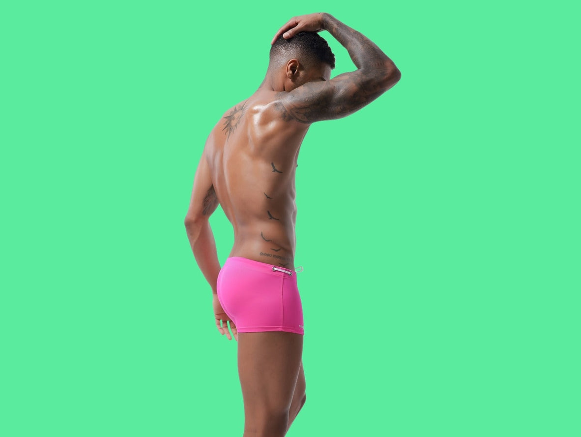 Bright fuchsia low-rise men's swim trunks with high-gloss finish and seamless side seams