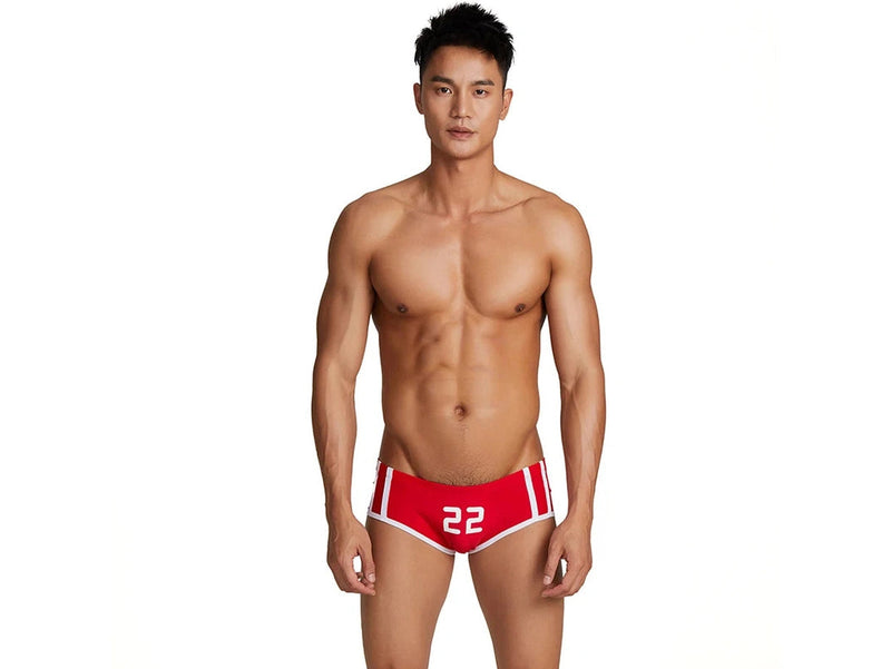 Blue low-rise swim trunks form-fitting detail on muscular model