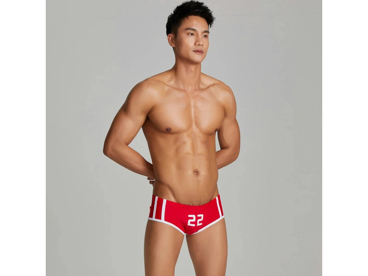 Red number 22 low-rise swim trunks three-quarter pose