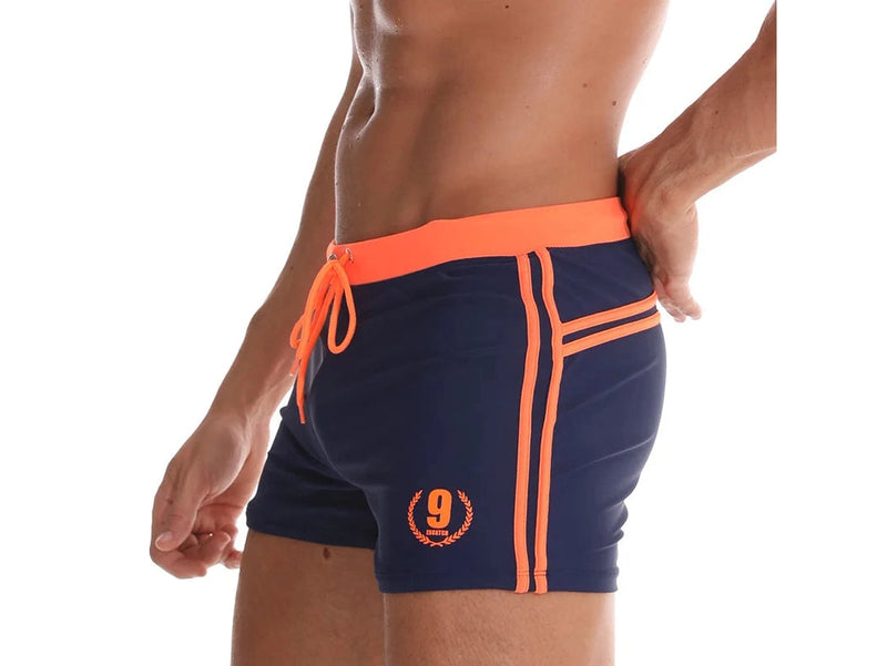 Cyan and navy blue athletic swim trunks with thin vertical stripe detail