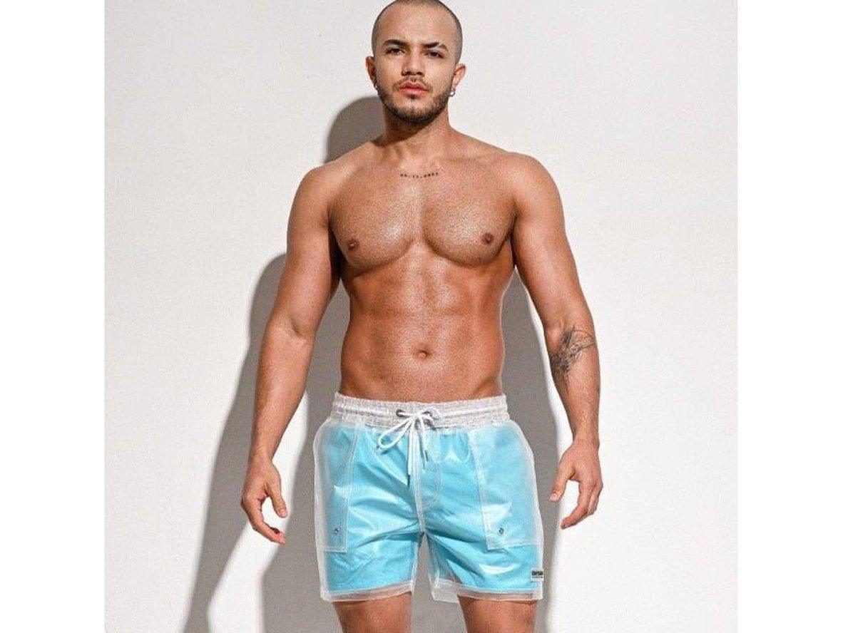 Light blue glossy sheer swim shorts for men with visible torso and tattoos