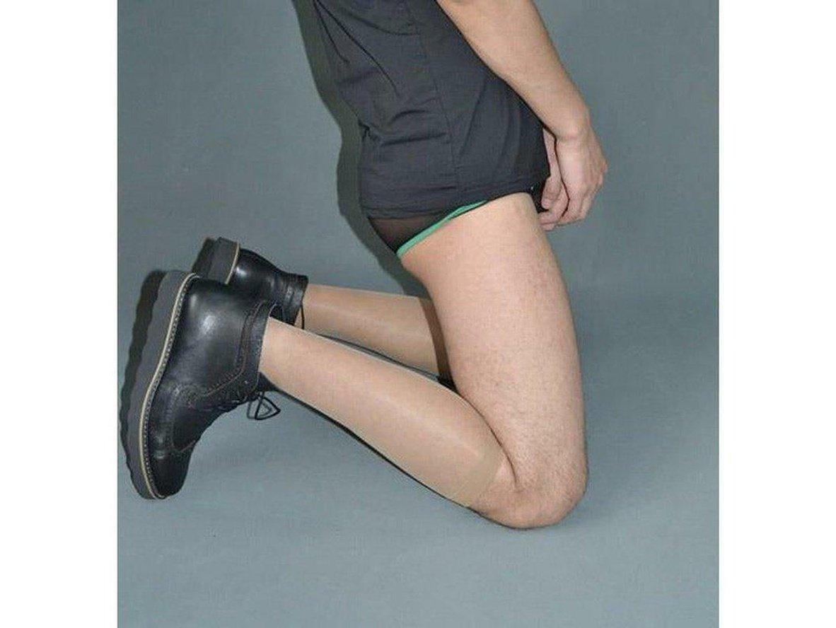 Seamless skin-toned men's pantyhose under black shorts showing smooth leg coverage
