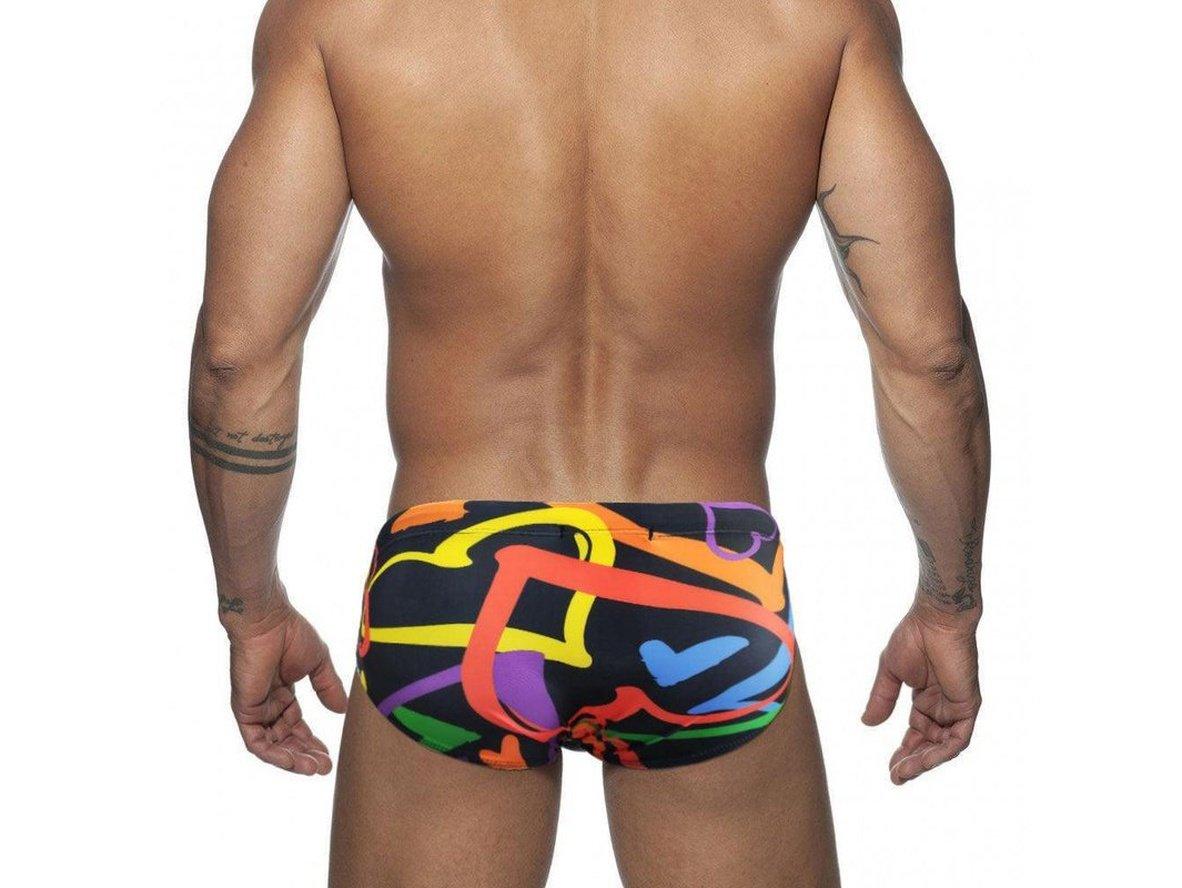 Back view of men's black swim briefs with colorful abstract shapes and white star