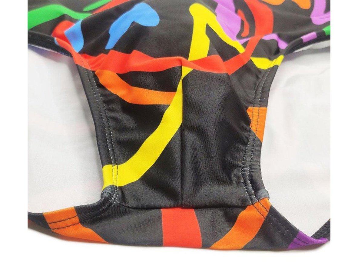 Close-up of reinforced seams and white lining on black patterned swim briefs